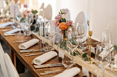 long set wedding table in wood with rolled napkins and wine glasses