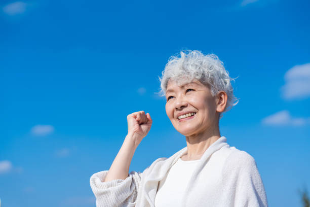 Senior woman posing with guts under the blue sky stock photo
