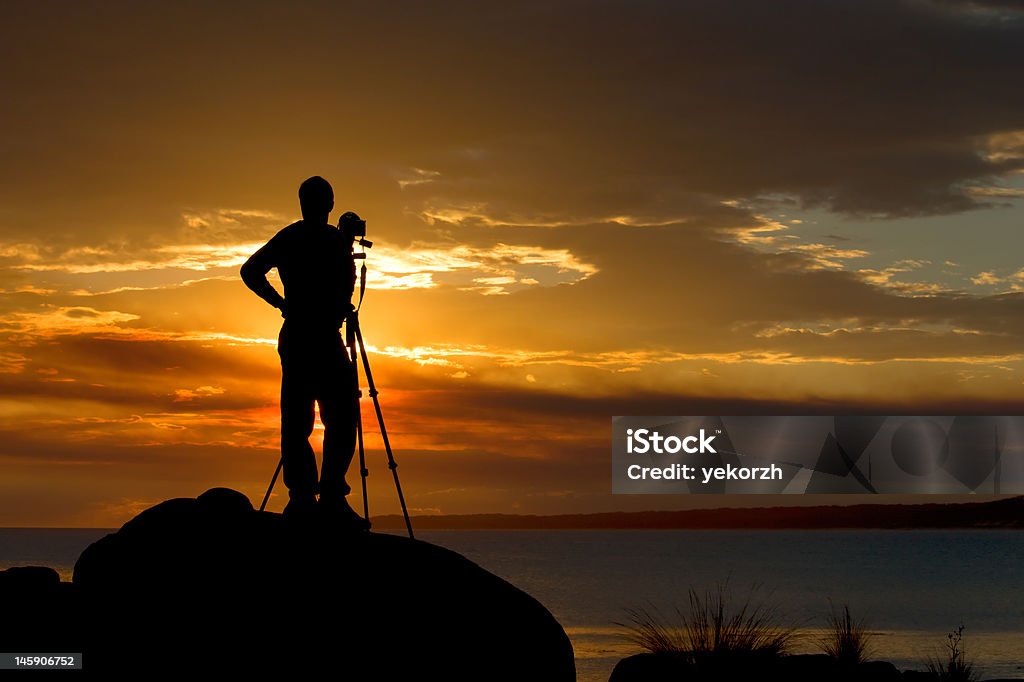 Photograper waiting for a sunset Photographer waiting for a right moment for a perfect shot Adult Stock Photo