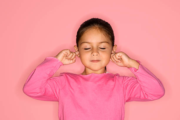 Girl with fingers in ears. stock photo