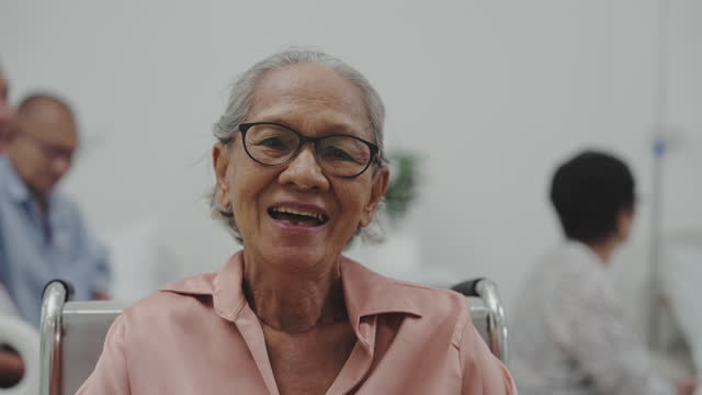 Portrait of senior woman sitting on wheelchair at nursing home