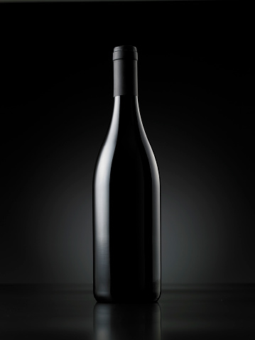 Wine bottle front of the black background.