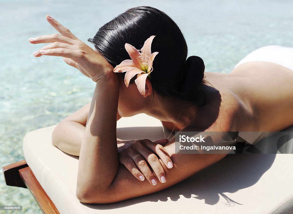 Beautiful woman taking sunbath Beautiful  woman laying near the ocean and taking sunbath Rear View Stock Photo