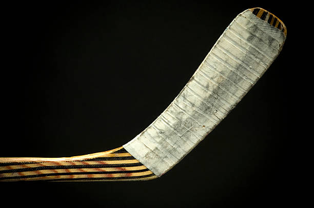 Closeup view of the bottom of a hockey stick on a black back stock photo