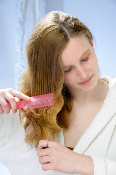 Young woman brushing red hair stock photo