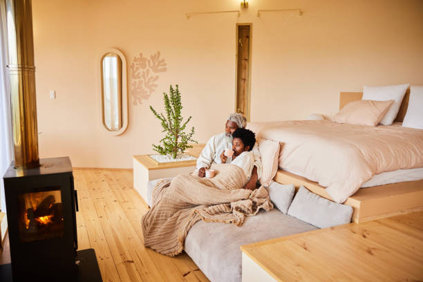 istock Couple in bathrobes drinking coffee in front of a fireplace during vacation 1459079493