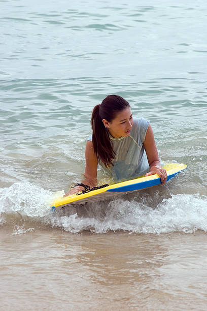 istock girl riding boogy board 145908054