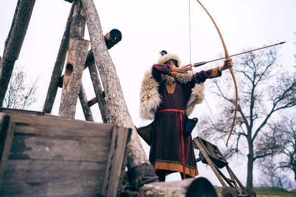 istock Female medieval warrior aiming with bow and arrow in front of the for 1459082103