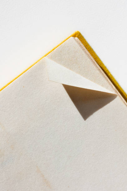 A dog-eared page in opened book on white table