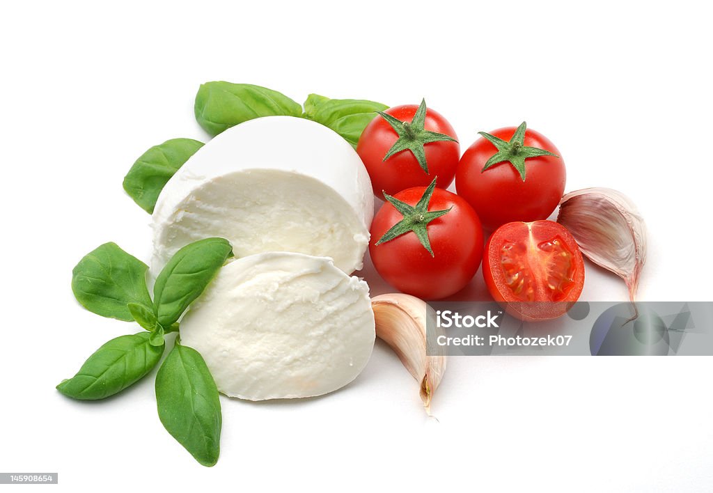 Mozzarella, tomatoes, basil and garlic Typical italian food isolated over white. Tomato Stock Photo