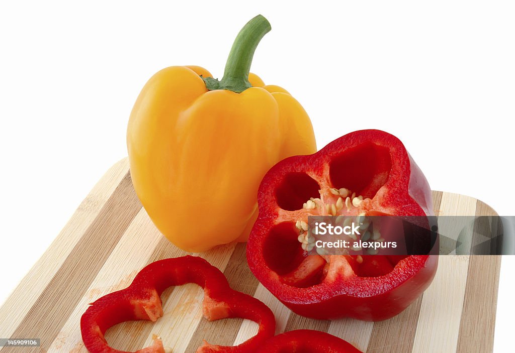 Red and yellow paprika on bamboo cutting board. Bamboo - Material Stock Photo