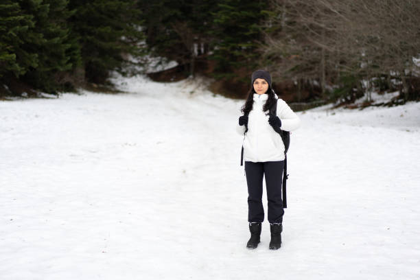 A woman stands on snow and looking admires
