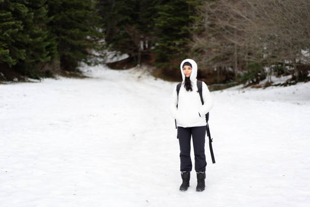 A woman stands on snow and looking admires