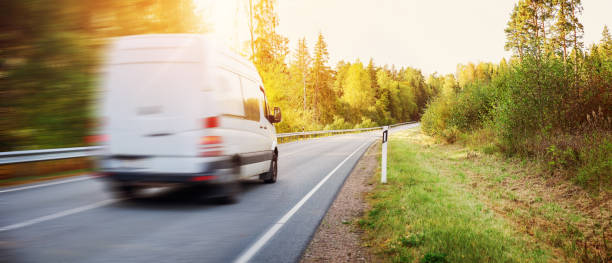 van poruszający się po wiejskiej drodze w parku przyrody o zachodzie słońca. - delivery van truck delivering moving van zdjęcia i obrazy z banku zdjęć