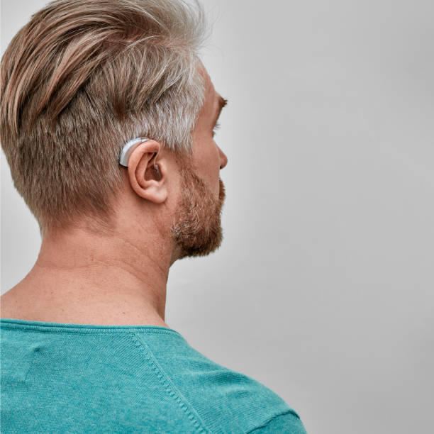 성인 남성의 귀 뒤에 보청기, 클로즈업. 청력 개선을 위한 솔루션 - body care audio 뉴스 사진 이미지