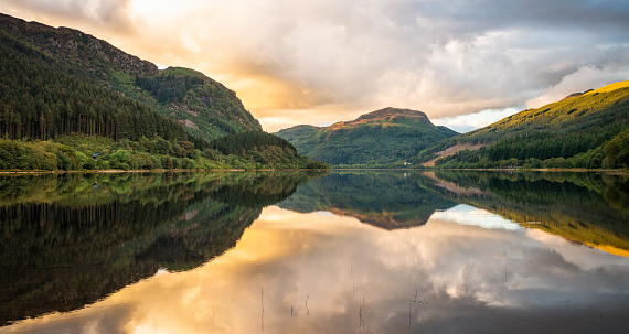 Panoramic view of the waters of Loch Lubnaig in Scotland's Trossachs region, calm at sunset in September.