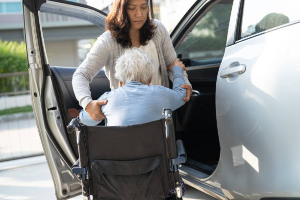 Asian senior or elderly old lady woman patient sitting on wheelchair prepare get to her car, healthy strong medical concept. Asian senior or elderly old lady woman patient sitting on wheelchair prepare get to her car, healthy strong medical concept. senior adult car nurse physical impairment stock pictures, royalty-free photos & images