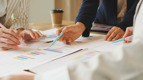 Closeup of multiethnic team of businesspeople brainstorm on project during corporate meeting in the office. Financial company concept.