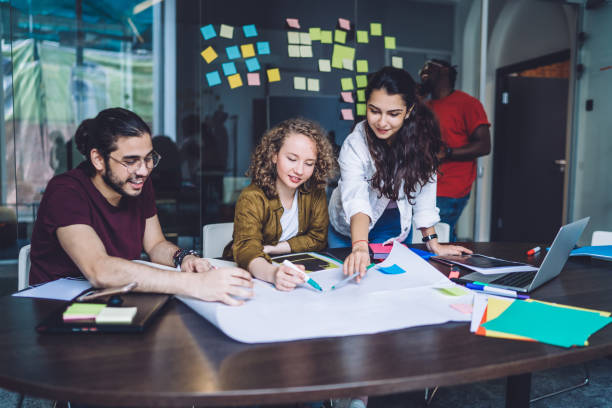 istock Confident employee pointing at sketch working with partners 1459106982