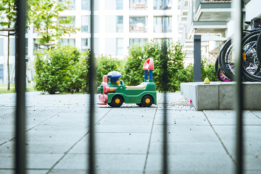 little toy car behind iron fence in new residential complex in Berlin