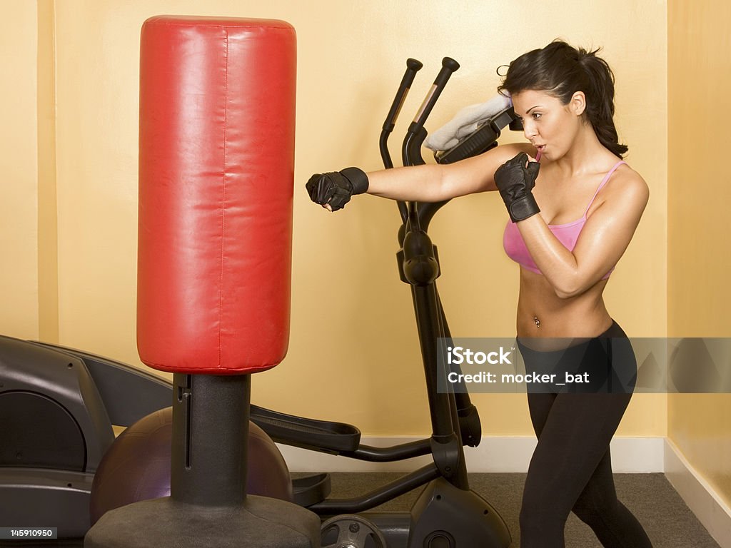 Female kickboxing training woman kickboxing with red punching bag 20-24 Years Stock Photo