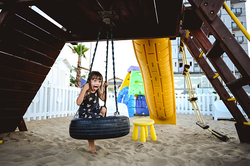 Little girl at a beach sandy playground.