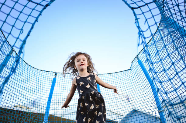 child jumping on a trampoline a summer time with sky view.