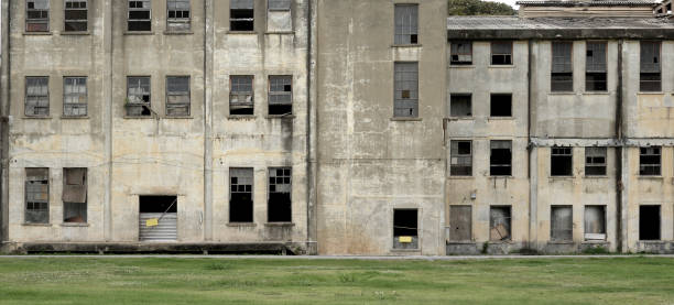 istock An Old abandoned building facade architecture with broken window ,concrete surface and green lawn 1459111327