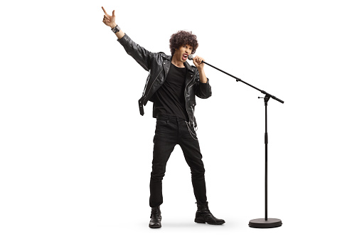 Man in a leather jacket singing on a microphone and pointing up isolated on white background