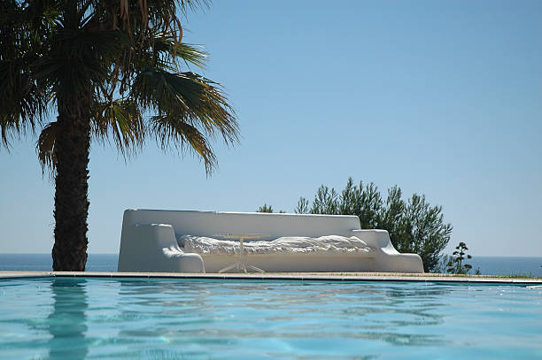 white bench poolside stock photo