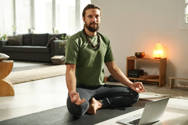 istock Man meditating in lotus position at home 1459120242