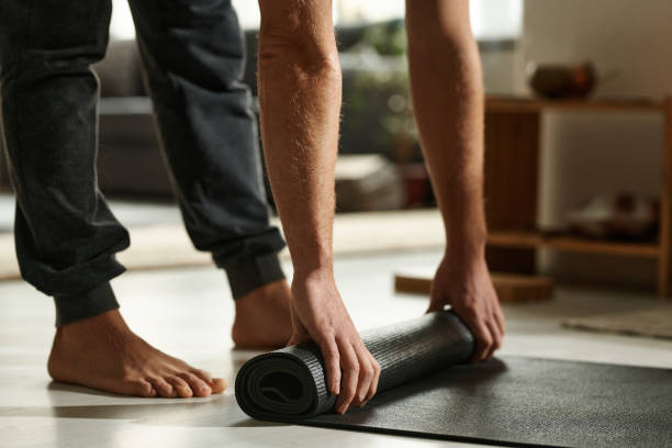 istock Man preparing mat for yoga exercises 1459121813