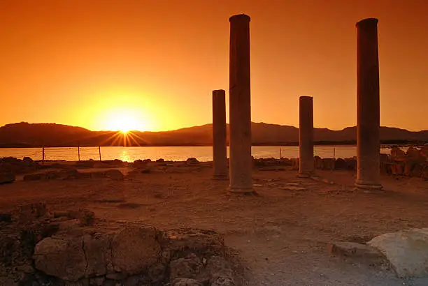 Sunset and pilars of ruins on Sardinian town of Nora