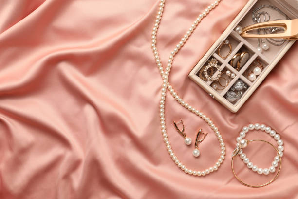 caja con lujosas joyas de perlas sobre tela rosa, plana. espacio para texto - pearl necklace earring jewelry fotografías e imágenes de stock