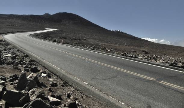 the winding road leading towards the summit of haleakalā, with the haleakalā observatory in the background. - haleakala national park mountain winding road road imagens e fotografias de stock