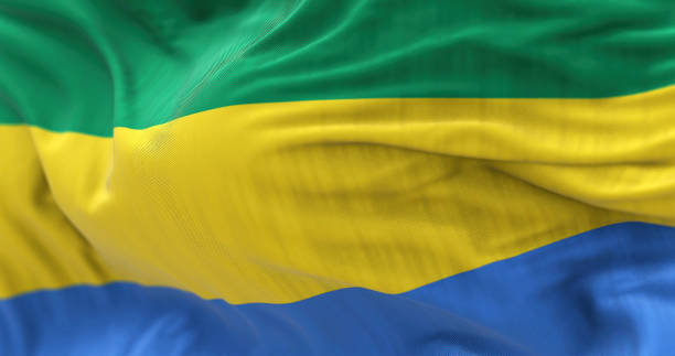 Close-up view of the Gabon national flag waving in the wind The Gabon national flag waving in the wind. The Gabonese Republic is a Central African Country. Rippled fabric. Textured background. Realistic 3d illustration. Close-up gabon stock pictures, royalty-free photos & images