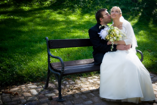 Wedding Couple sitting on the bench in the park