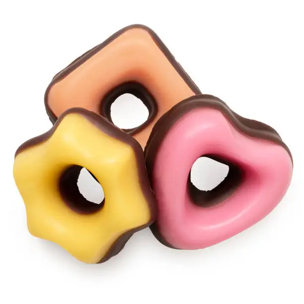 Yellow, orange and pink christmas fondant sweets dipped in chocolate isolated on white. Top view.