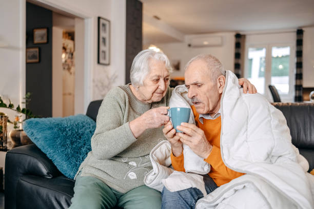 istock Old couple having flu at home and drinking hot tea 1459130218