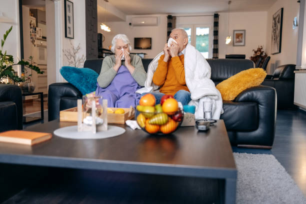 Old couple having flu at home stock photo
