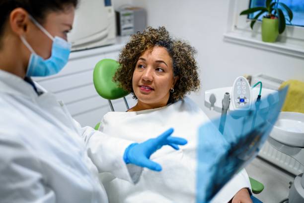Dentist explaining tooth x-rays to a female patient stock photo