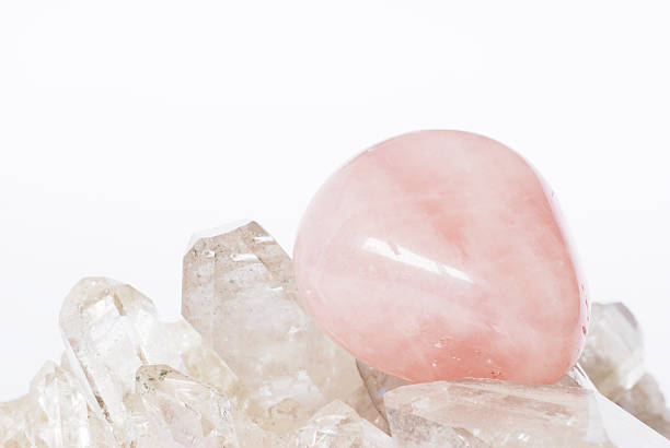 Rose quartz on crystals Rose quartz laid on clear crystals with plain backgground la geode stock pictures, royalty-free photos & images