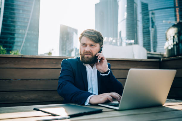 istock Thoughtful confident formal guy working with laptop on terrace 1459135898