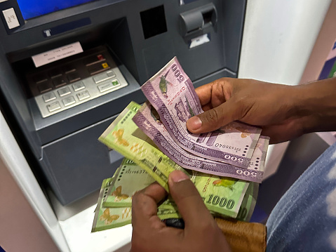 Stock photo showing close-up view of cash withdrawal being counted by an unrecognisable person at a cashpoint (ATM - automatic teller machine). Cash machine fraud is an ongoing problem for banks, with a growing percentage of debit and credit cards being cloned or stolen.