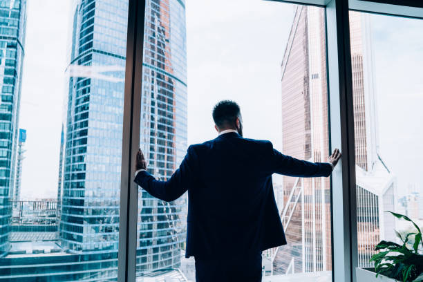 istock Smart male manager looking at cityscape from window in office 1459139402