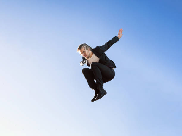 istock business man doing a jump with blue sky background wear suit 1459141177