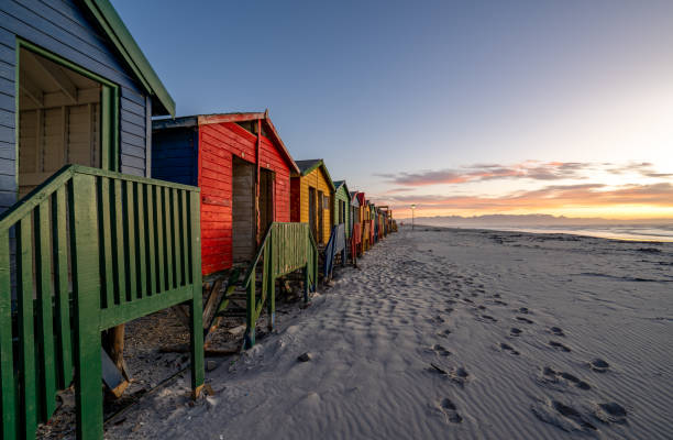 형형색색으로 칠해진 해변 오두막 위로 생생한 일출 
남아프리카 공화국 케이프타운 외곽의 케이프 반도 기슭에 있는 무이젠버그 해변 - cape town beach hut multi colored 뉴스 사진 이미지