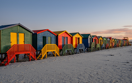Vibrant sunrise over the colorfully painted beach huts on 
Muizenberg Beach at the base of the Cape Peninsula outside Cape Town, South Africa.