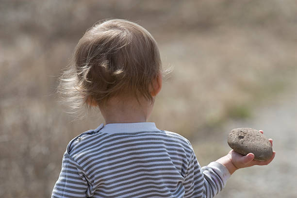 Child ready to throw rock stock photo