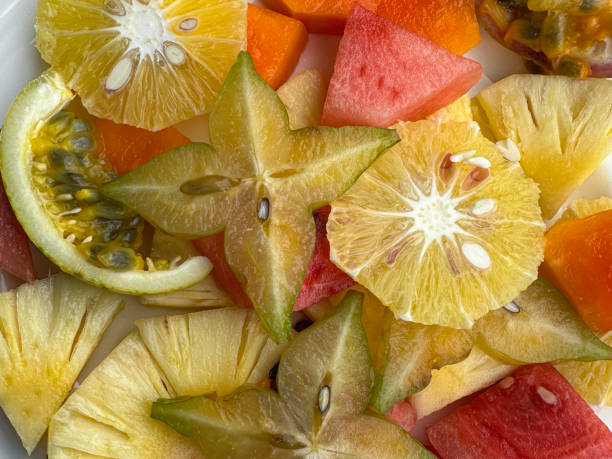 istock Full frame image of fresh, tropical fruit salad with sliced orange, pineapple, starfruit, watermelon and passionfruit, elevated view 1459146730